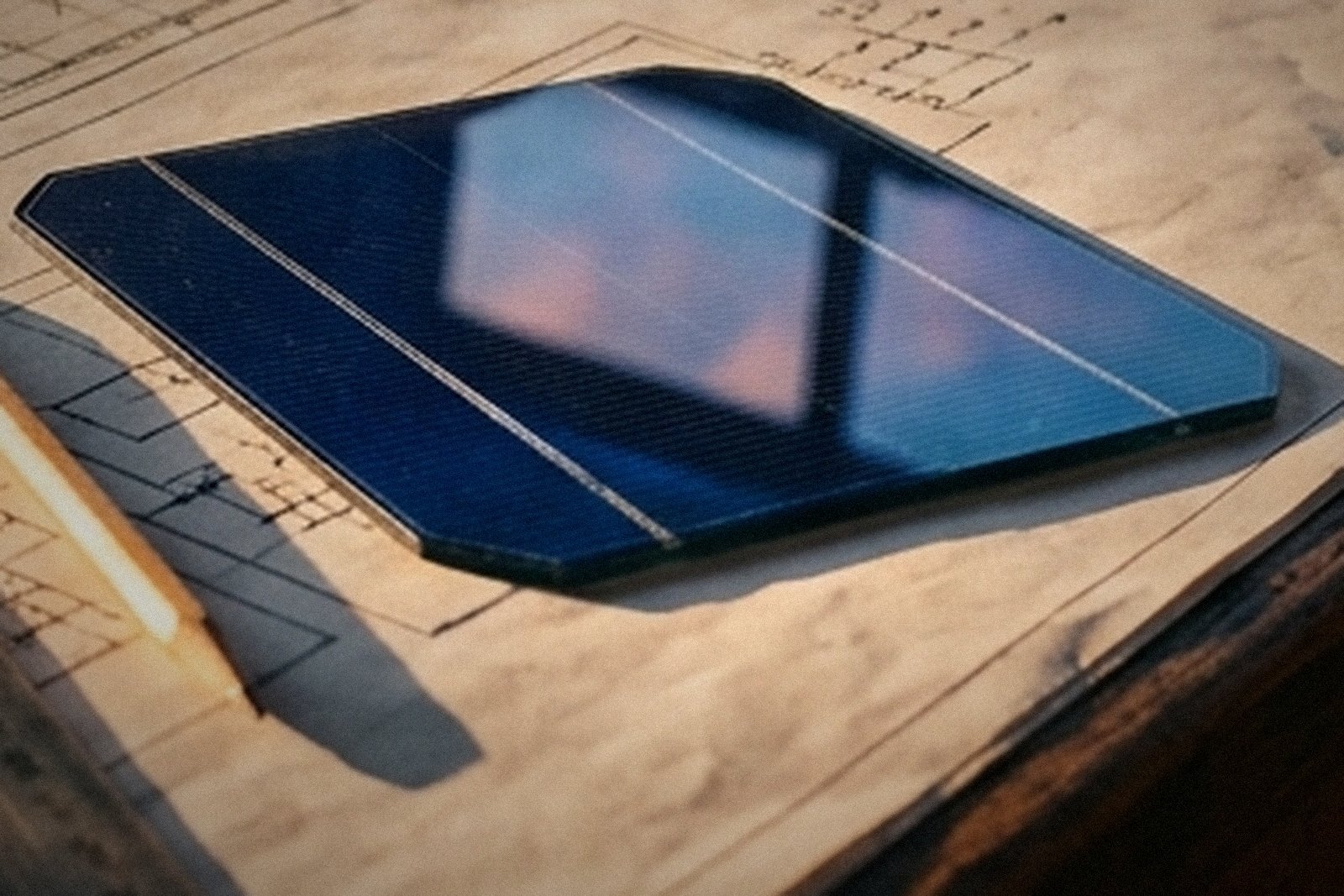 Detalhe de uma célula fotovoltaica com o vidro refletindo o céu do entardecer